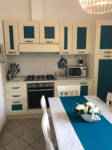 a kitchen with white cabinets and a table with a bowl of flowers at Acquamarina in Forte dei Marmi