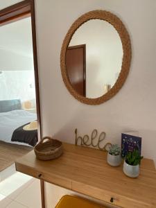 a mirror on a wall next to a wooden table at 3 Castelos Sunset - Praia da Rocha in Portimão +16 photos