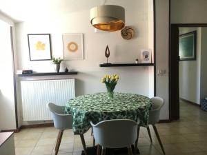 a dining room with a table and chairs with a vase of flowers at apartmentsIT vista mare in Alba Adriatica