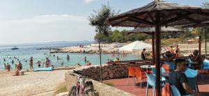 a beach with a bunch of people in the water at Apartman Jadranka in Vir