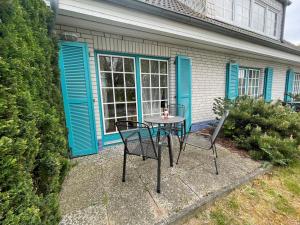 a table and chairs in front of a house at Ferienwohnung #9 Am Neuensiener See - Seedorf in Sellin