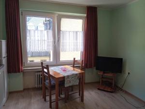 a dining room with a table and a television at Ferienwohnungen Schenk Schmitz in Bad Bertrich