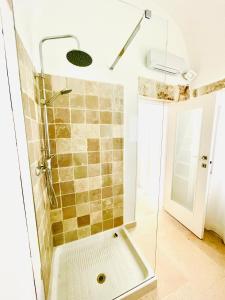 bagno con doccia e porta in vetro di WHITE STONE- La Terrazza a Ostuni