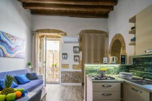 a kitchen and living room with a blue couch at The Good Place in Cagliari