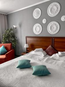 a bedroom with a bed with pillows and plates on the wall at Vernisage on Ushinskogo in Saint Petersburg