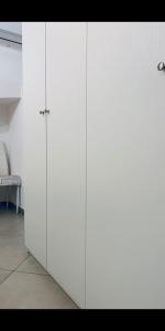 a white cabinet with two doors in a room at Dimora Sportelli in Polignano a Mare