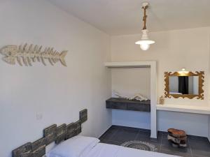 a bedroom with a bed and a mirror at Family Villages Santorini in Vlychada Beach