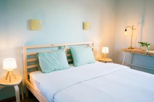 een slaapkamer met een groot wit bed met blauwe kussens bij Maison la Gileppe in Jalhay