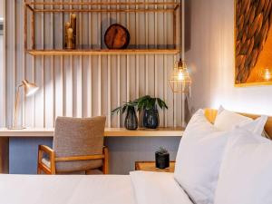 a bedroom with a bed and a chair and a table at Grand Mercure Sao Paulo Vila Olimpia in São Paulo