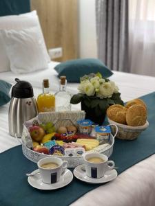 una bandeja de comida en una cama con dos tazas de café en Brekner Rooms, en Sibiu
