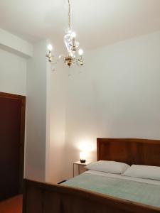 1 dormitorio con cama y lámpara de araña en Annina Home, en Paestum