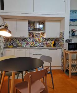 a kitchen with white cabinets and a table and chairs at Annina Home in Paestum