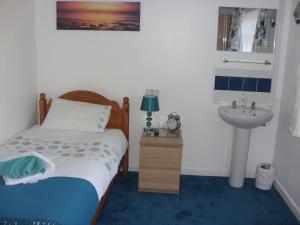 1 dormitorio con cama y lavamanos en Ashdene Guest House, en Southampton