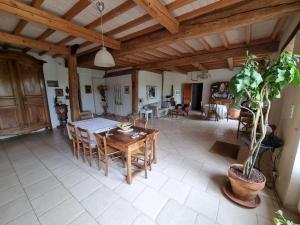ein Esszimmer und ein Wohnzimmer mit einem Tisch und Stühlen in der Unterkunft Chambre d'hôtes à Mignaloux-Beauvoir- le Thil in Mignaloux-Beauvoir