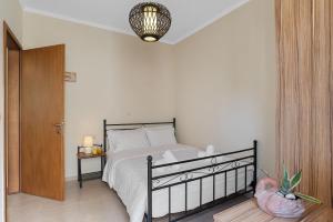 - une chambre avec un lit avec un cadre noir et une lampe dans l'établissement Amphitrite Beach House, à La Canée