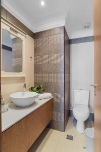 La salle de bains est pourvue d'un lavabo et de toilettes. dans l'établissement Amphitrite Beach House, à La Canée
