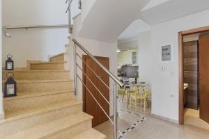 - un escalier dans une maison avec des murs blancs et une cuisine dans l'établissement Amphitrite Beach House, à La Canée
