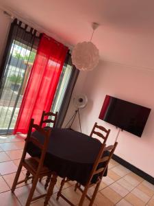 - une salle à manger avec une table, des chaises et une télévision dans l'établissement Maison vivancos, à Narbonne