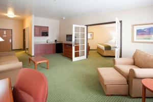 a hotel room with a bed and a living room at Holiday Inn Express Hotel & Suites Gunnison, an IHG Hotel in Gunnison