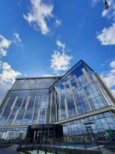 duży szklany budynek z niebieskim niebem w obiekcie Бутик-отель Status w Brześciu