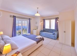 a bedroom with a large bed and a blue couch at Villa Günbatımı in Kaş +16 photos