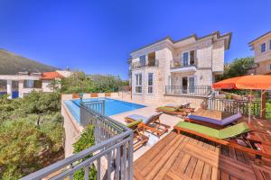 a house with a deck with a swimming pool at Villa Günbatımı in Kaş