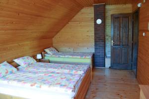 Un pat sau paturi într-o cameră la Ivola Vendégház