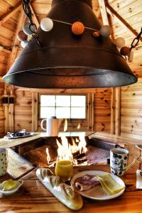 einen Kronleuchter, der über einem Tisch in einer Blockhütte hängt in der Unterkunft Chalet Le Paradou Adults only in Lessive