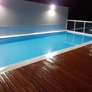 a empty swimming pool with a wooden floor at Recanto Ribas in Ubatuba