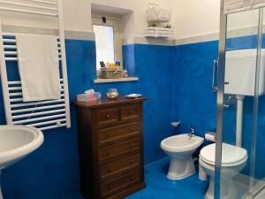 bagno blu con servizi igienici e lavandino di Villa Priscilla a Cinisi