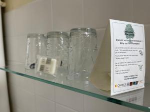 a bunch of glass jars sitting on a glass shelf at Coco Marco Hôtel in Nyons