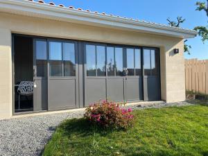 un garage avec des portes en verre sur une maison dans l'établissement Atelier de Tony et Marie, à Mérignac