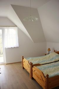 a bedroom with a wooden bed in a room with a window at Villa Prémecz in Zalakaros