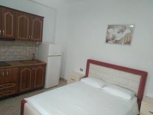 a bedroom with a bed and a kitchen with a refrigerator at Villa Shpetim Zogaj. in Ksamil
