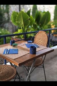 a wooden table with two chairs and a table with utensils at Coco Marco Hôtel in Nyons