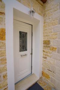 a white door in a brick wall at Astrali Stone Villas in Paramythia