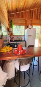 a kitchen with a table with a plate of fruit on it at Bangalô-Nosso Escritorio-Hospedagem Rural in Muniz Freire
