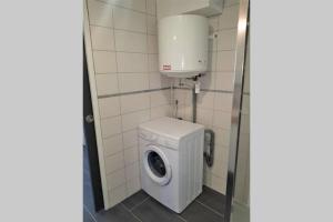 a washer and dryer in a small bathroom at Studio neuf 001 proche gare TGV, A36 et Hôpital in Botans