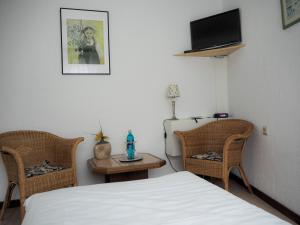 una camera da letto con un letto, due sedie e un tavolo di Mutter Siepe a Lüdinghausen