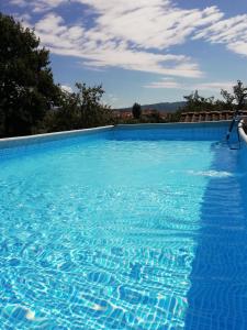 uma grande piscina com água azul em Il Giglio Rosso em Borgo a Buggiano