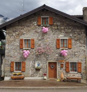 a stone house with a bike on the side of it at Casa all’antica fontana in Sùtrio