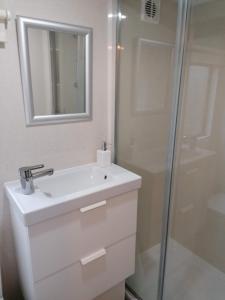y baño blanco con lavabo y ducha. en Poplar Lodge Log Caravan en Kirkby on Bain