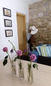 three vases with flowers on a table in a living room at House Beatrix in Stari Grad