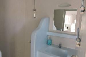 a white bathroom with a sink and a mirror at Elena Studio in Logothetiánika