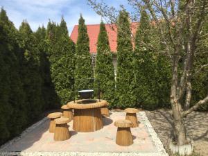 une fontaine dans un jardin avec des tabourets en bois dans l'établissement Süti Nyaraló, à Balatonmáriafürdő