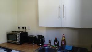 a kitchen counter with a microwave and a sink at Harbor View in Uig