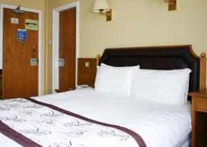 A bed or beds in a room at Cardiff Sandringham Hotel 