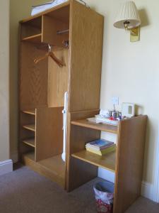 a room with a wooden cabinet and a wooden shelf at Cardiff Sandringham Hotel in Cardiff