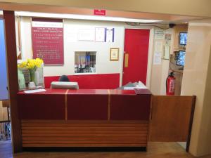 een ticketbalie in een bibliotheek met een rode muur bij Cardiff Sandringham Hotel in Cardiff