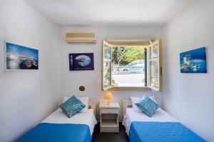 two beds in a room with a window at Margarita Studios in Parikia